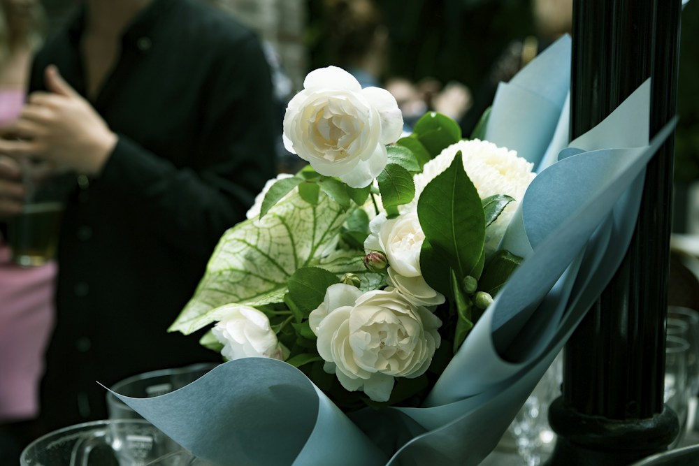 White roses and green leaves in a softly rounded bouquet.